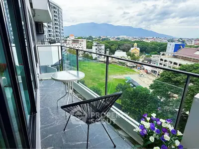 Stunning balcony view with modern furniture overlooking lush greenery and mountains.