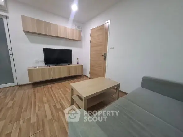 Modern living room with sleek wooden flooring and minimalist furniture design.