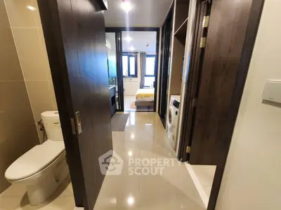 Modern apartment hallway with bathroom and laundry area, sleek design and bright lighting.