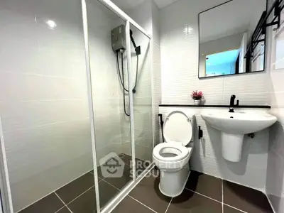 Modern bathroom with glass shower and sleek fixtures in contemporary apartment.
