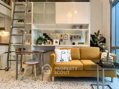 Modern living room with yellow sofa and mezzanine, featuring stylish decor and open shelving.