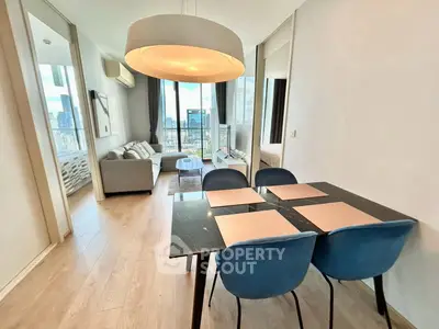 Modern living room with dining area and city view, featuring stylish furniture and large windows.