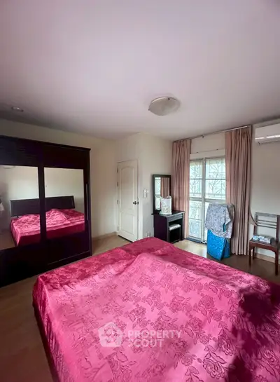 Cozy bedroom with elegant decor and ample natural light, featuring a large wardrobe and stylish furnishings.