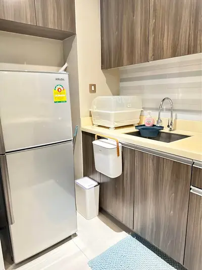 Modern kitchen with sleek cabinetry and stainless steel fridge in a compact layout.