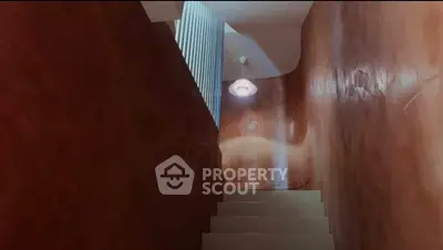 Elegant staircase with modern lighting and textured walls in a stylish home.