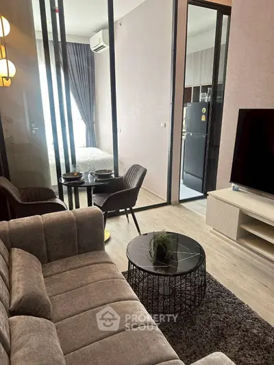 Modern living room with stylish furniture and open view to kitchen and bedroom