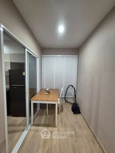 Cozy dining nook with wooden table and sliding glass doors in modern apartment.