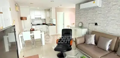Modern living room with open kitchen, stylish decor, and comfortable seating in a bright apartment.