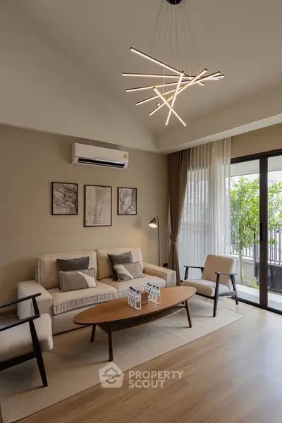 Modern living room with stylish lighting and large windows opening to a balcony.
