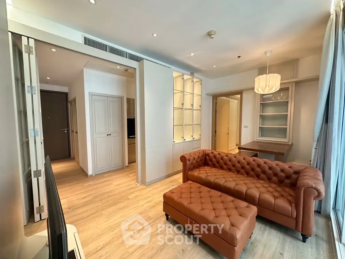Spacious living room with elegant leather sofa and modern decor in a stylish apartment.