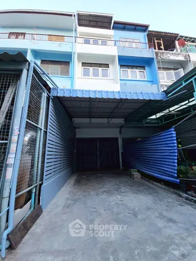 Charming townhouse exterior with covered parking in vibrant urban setting.