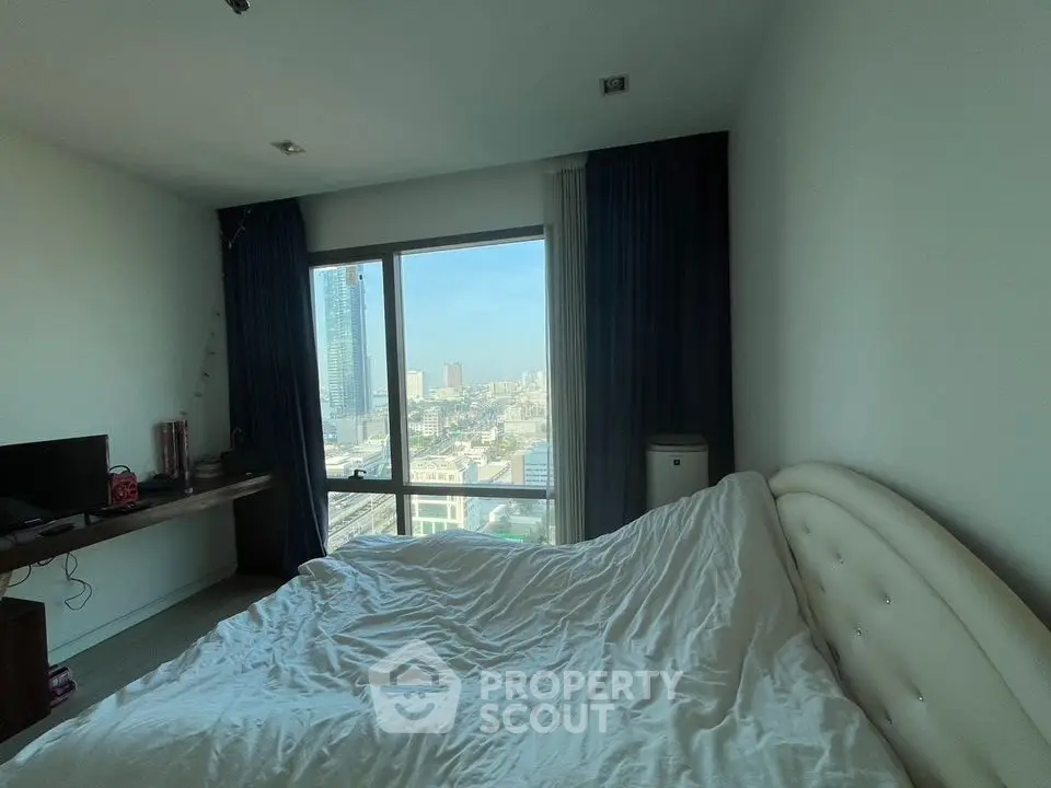 Spacious bedroom with city view, featuring a cozy bed and modern decor.