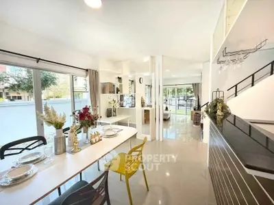 Spacious open-plan living and dining area with modern decor and large windows.