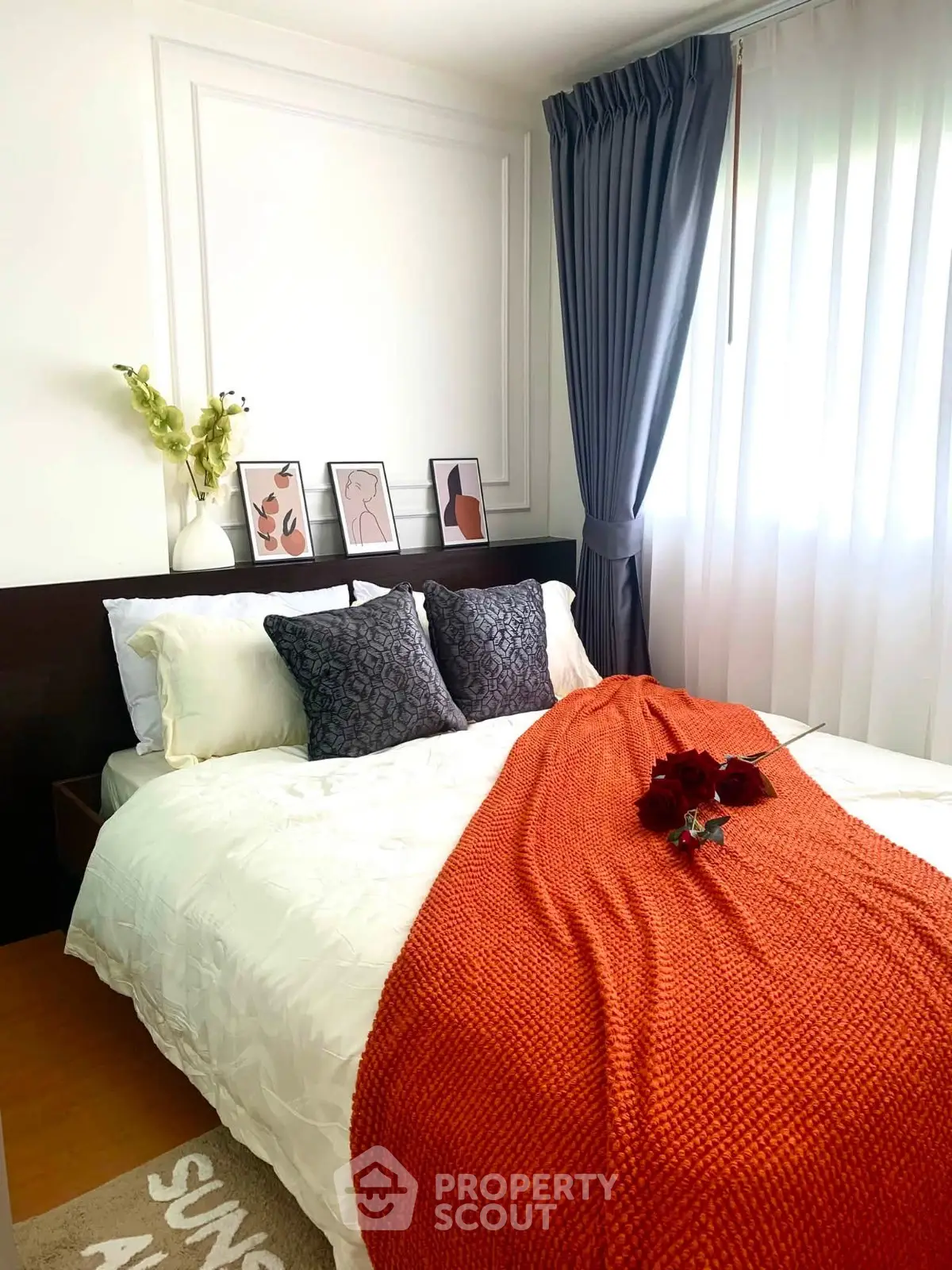 Cozy bedroom with stylish decor and natural light, featuring elegant bedding and modern artwork.