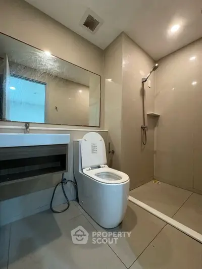 Modern bathroom with sleek fixtures and spacious shower area in a contemporary home.