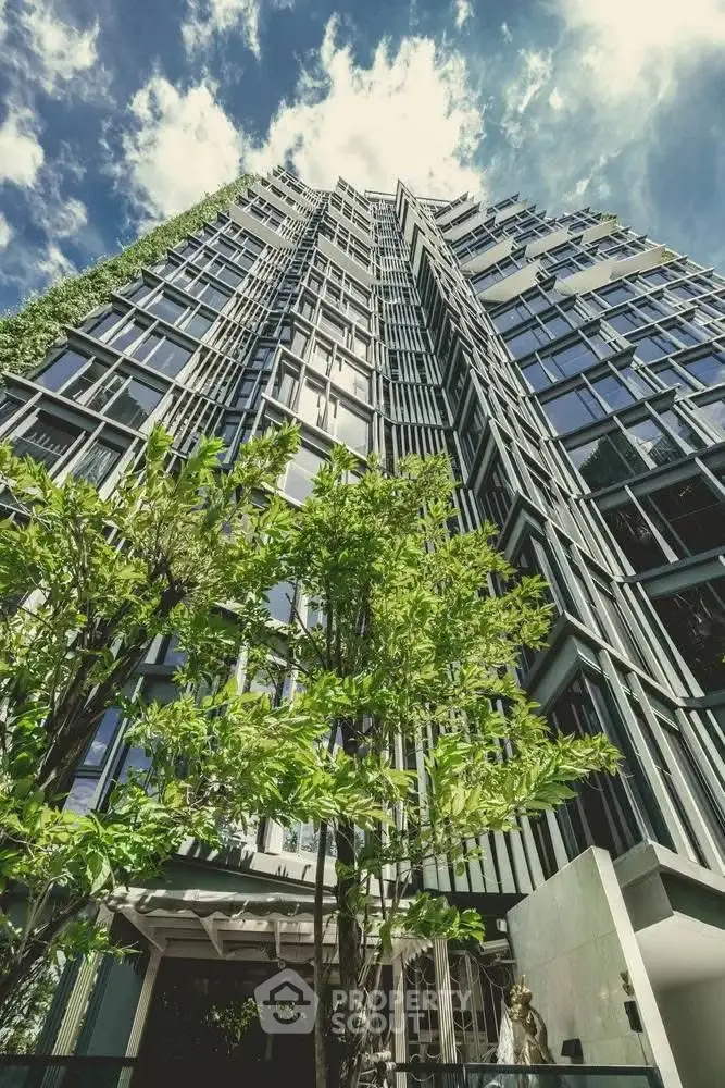 Modern high-rise building with lush greenery and striking architectural design.