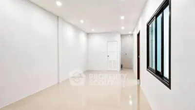 Spacious empty room with large window and modern tile flooring, perfect for customization.