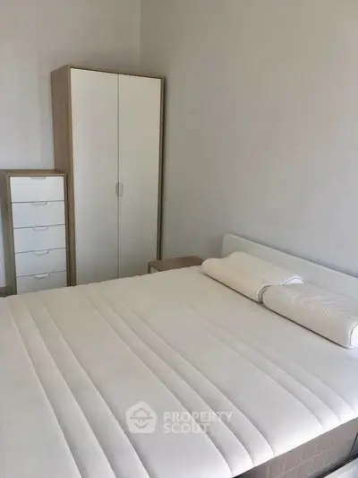 Spacious bedroom with modern furniture and comfortable bed in a minimalist design.
