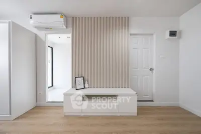 Modern minimalist living room with sleek white furniture and wooden flooring