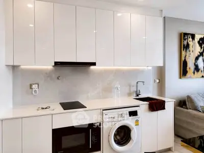 Modern kitchen with sleek white cabinets, built-in appliances, and stylish decor