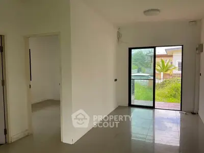 Spacious interior with sliding glass door leading to lush garden view.