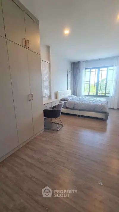 Spacious bedroom with large windows and modern furnishings