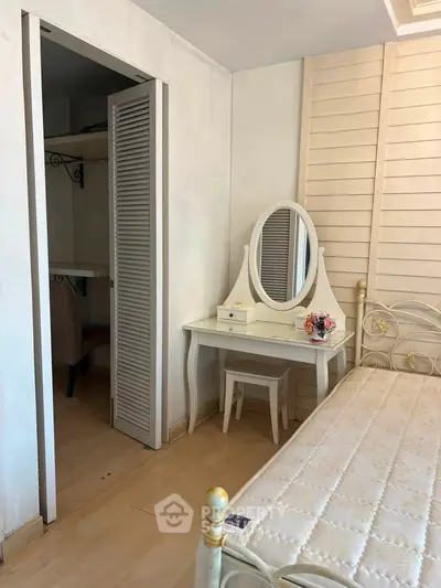 Charming bedroom with elegant vanity and cozy closet space, perfect for a serene retreat.