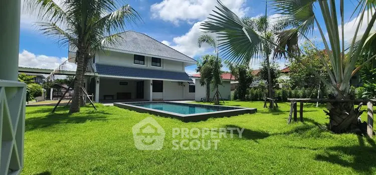 Charming suburban home with lush garden and private pool under clear blue sky.