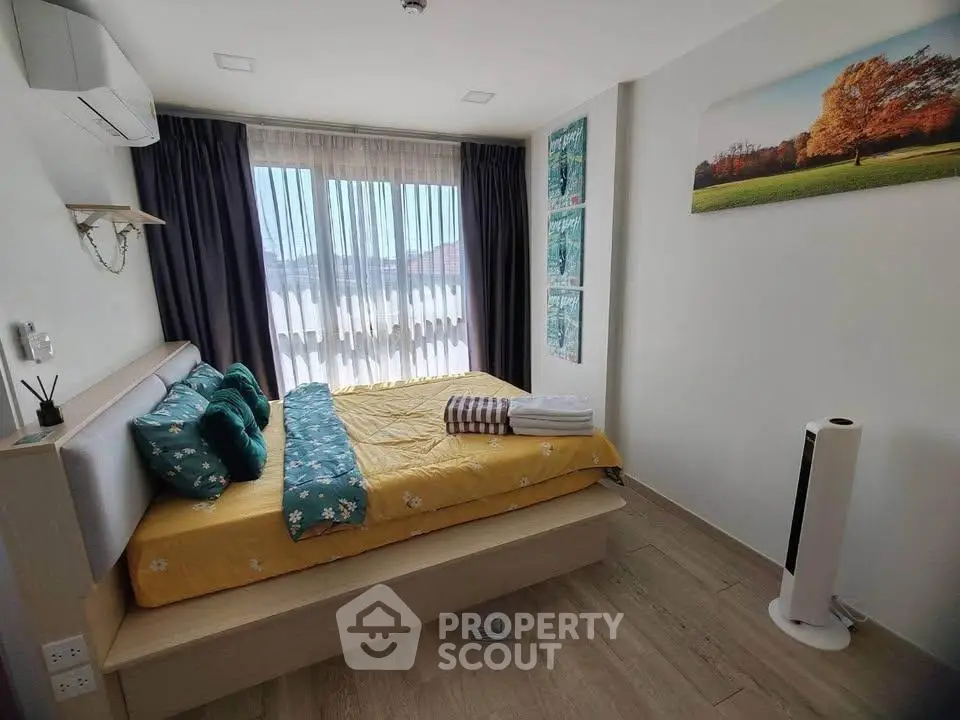 Cozy bedroom with modern decor, large window, and stylish furnishings in a bright apartment.