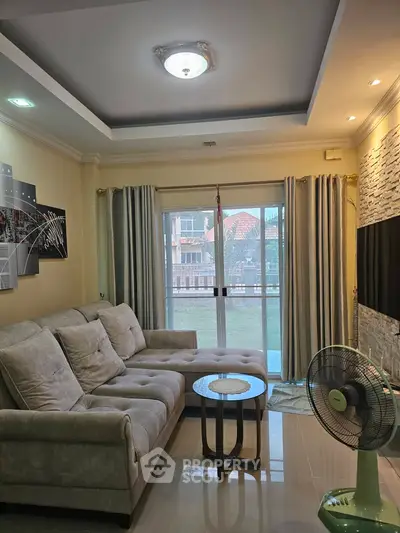 Cozy living room with plush sofa and modern decor, featuring large windows for natural light.