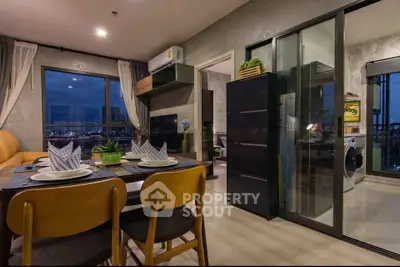 Modern dining and living area with city view, stylish decor, and open kitchen layout.