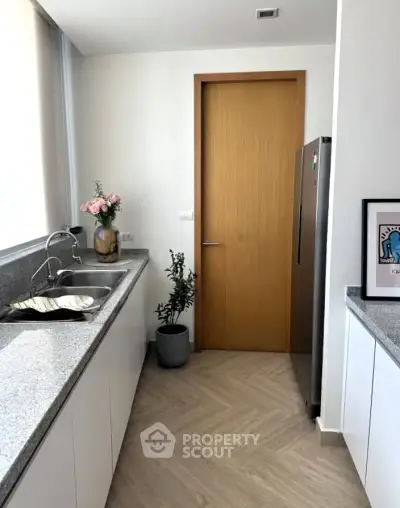 Modern kitchen with sleek countertops and stainless steel fridge