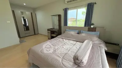 Spacious bedroom with natural light and modern furnishings, perfect for relaxation.