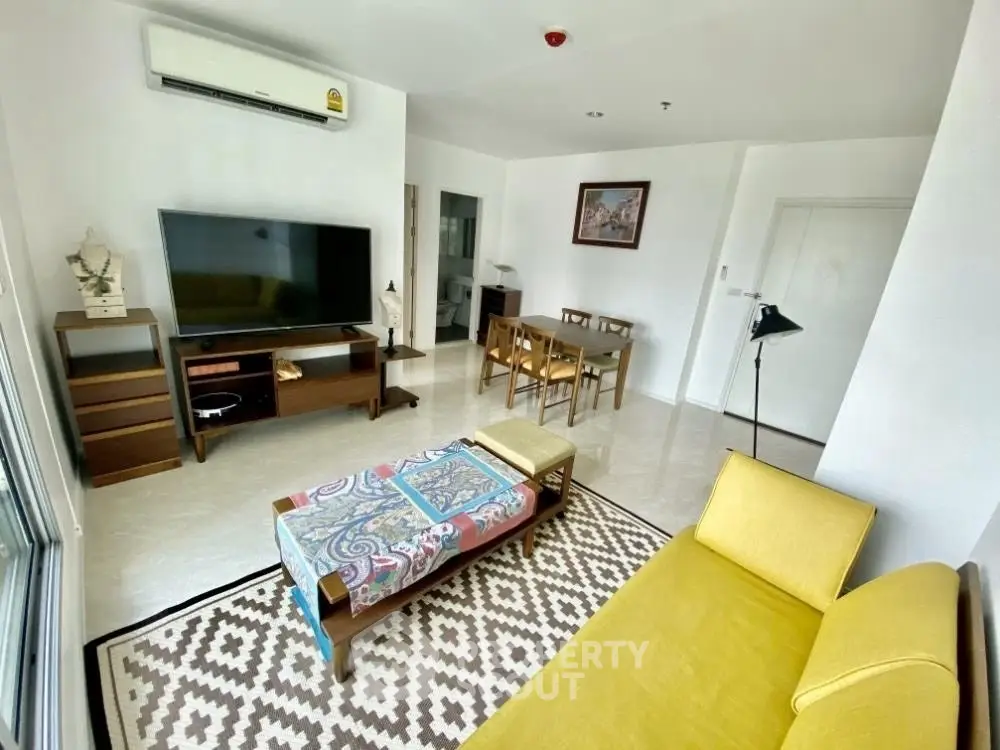 Spacious living room with modern decor and large TV, perfect for relaxation.
