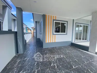 Modern house exterior with sleek design and spacious tiled patio