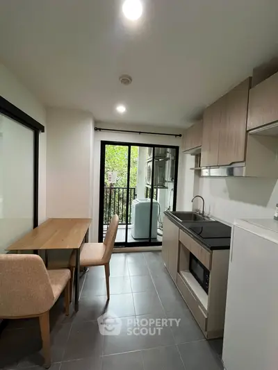 Modern kitchen with dining area and balcony view in a stylish apartment