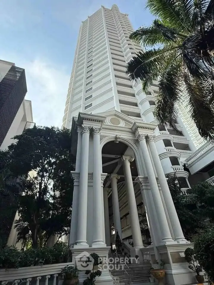 Majestic high-rise building with grand entrance and lush greenery