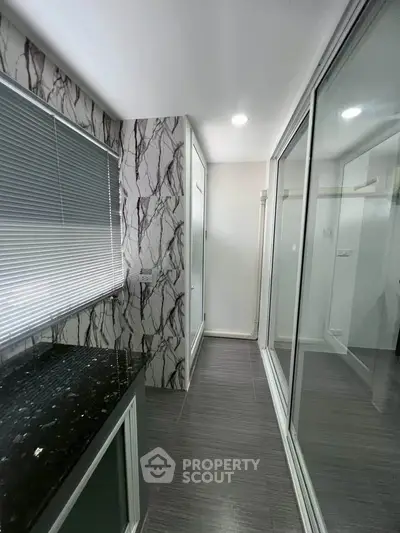 Modern bathroom with marble accents and sleek glass shower doors