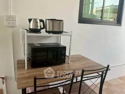 Cozy kitchen corner with modern appliances and wooden table setup.