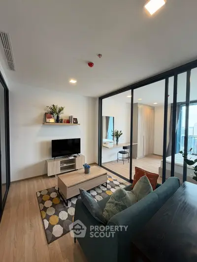 Modern living room with stylish decor and open layout, featuring a cozy seating area and natural light.