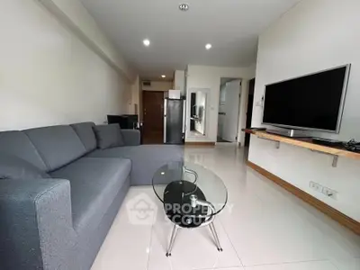 Modern living room with sleek furniture and large TV in a stylish apartment.