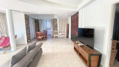 Spacious living room with modern decor and large TV