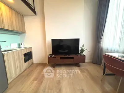 Modern living room with sleek TV stand and compact kitchen area, perfect for urban living.