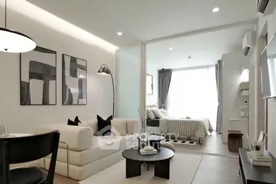 Modern open-plan living room with stylish decor and cozy bedroom view