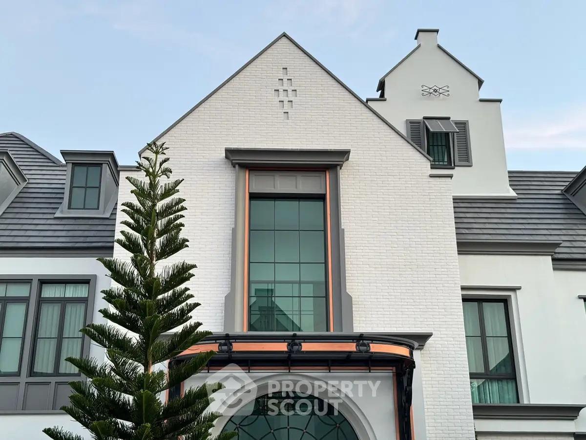 Elegant modern house exterior with large windows and unique architectural design.