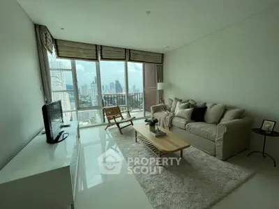 Spacious living room with modern furniture, large windows offering a panoramic city view, and a cozy ambiance perfect for relaxation and entertaining guests.