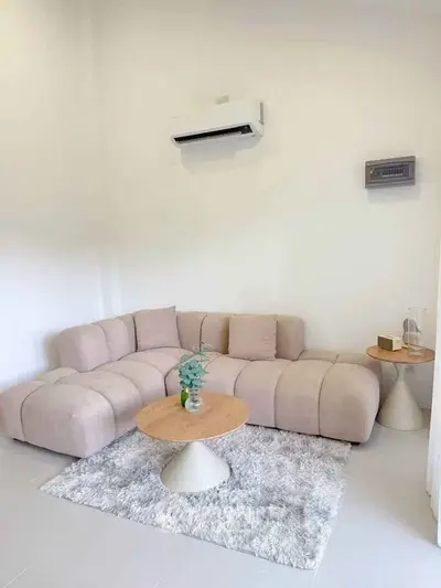 Modern living room with stylish beige sectional sofa and chic coffee table on plush rug.