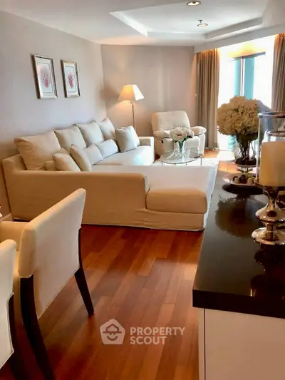 Elegant living room with cozy beige sofa and wooden flooring, perfect for relaxation.