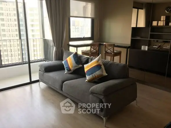 Modern living room with stylish sofa and balcony view in high-rise apartment