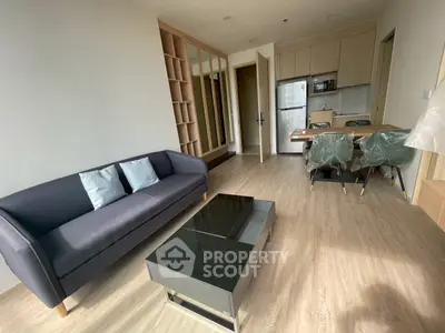 Modern living room with sleek furniture and open kitchen layout in a stylish apartment.